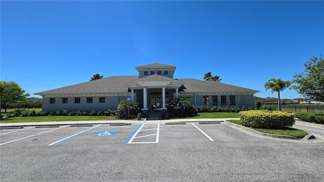 view of building exterior featuring uncovered parking and fence