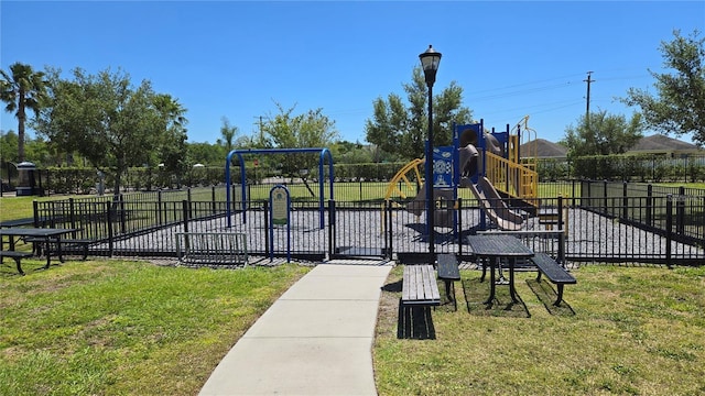 communal playground featuring fence and a yard