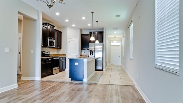 kitchen featuring a sink, appliances with stainless steel finishes, light wood-style flooring, and visible vents