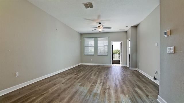 unfurnished living room with visible vents, dark wood finished floors, ceiling fan, and baseboards