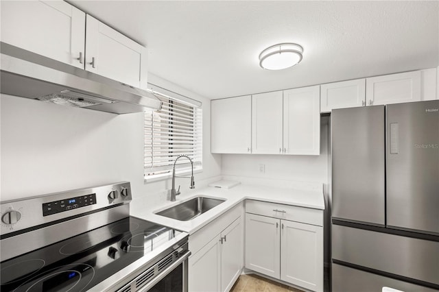 kitchen with light countertops, white cabinetry, under cabinet range hood, a sink, and appliances with stainless steel finishes