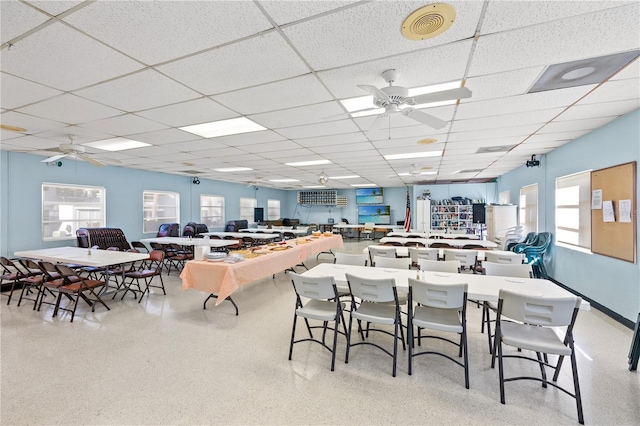 dining area with ceiling fan, visible vents, a drop ceiling, and speckled floor
