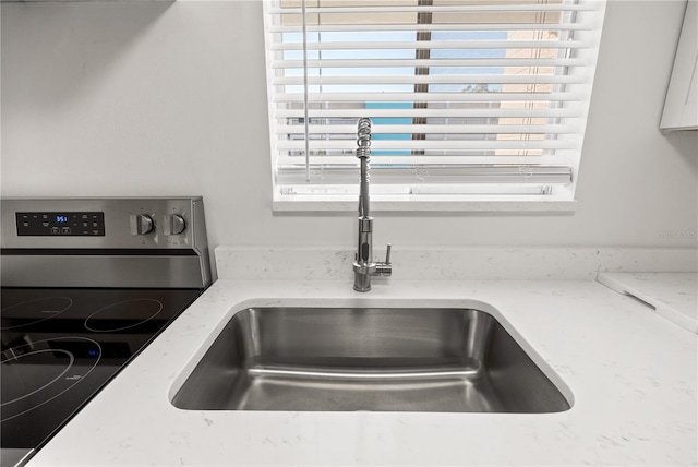 room details with a sink and light stone countertops