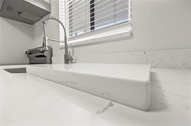 interior details with a sink and range hood
