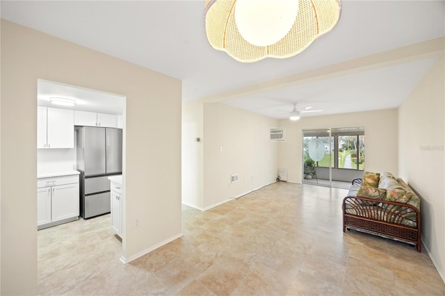 interior space with ceiling fan, baseboards, and a wall mounted air conditioner