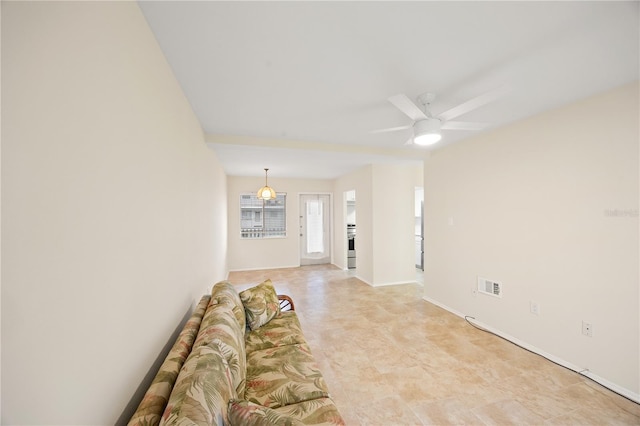 unfurnished living room featuring visible vents, a ceiling fan, and baseboards