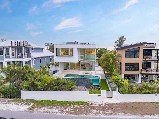 rear view of property featuring a patio area, fence private yard, and a fenced in pool