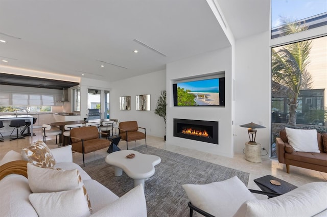 living room with a warm lit fireplace and recessed lighting