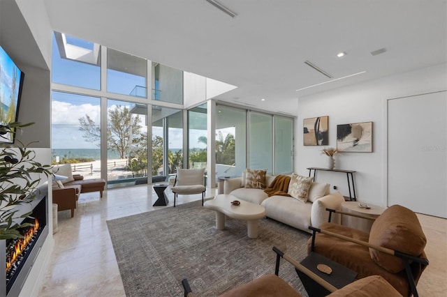 living room with a water view, expansive windows, and light tile patterned flooring