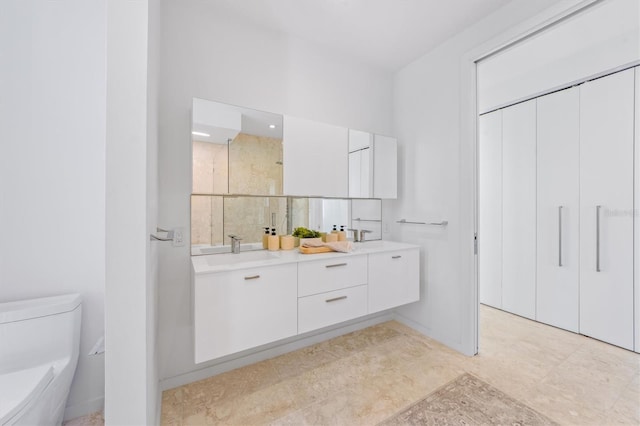 full bathroom with toilet, a stall shower, double vanity, and a sink