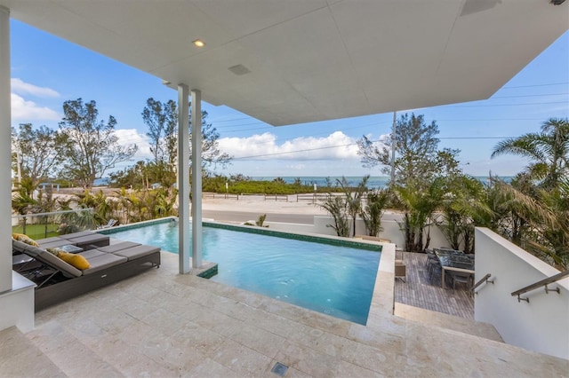 outdoor pool with a patio area and a fenced backyard