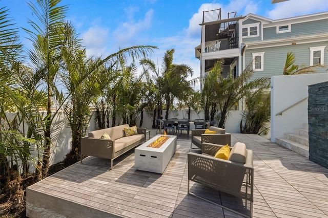 wooden deck with fence private yard and an outdoor living space with a fire pit