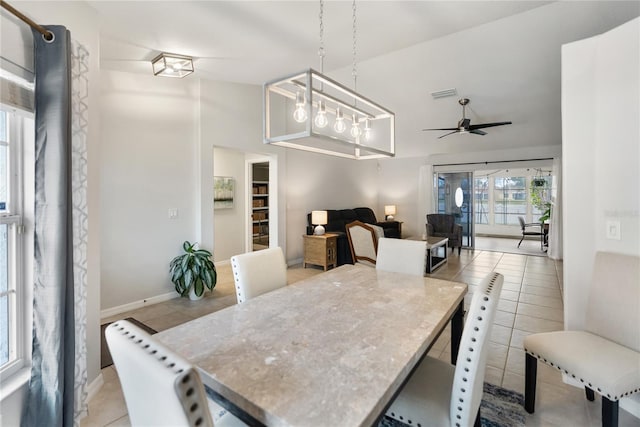 dining room with lofted ceiling, light tile patterned flooring, a ceiling fan, visible vents, and baseboards