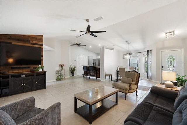 living area with light tile patterned floors, vaulted ceiling, and baseboards