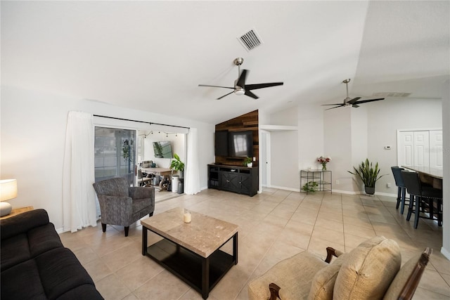 living area with visible vents, baseboards, ceiling fan, vaulted ceiling, and light tile patterned flooring