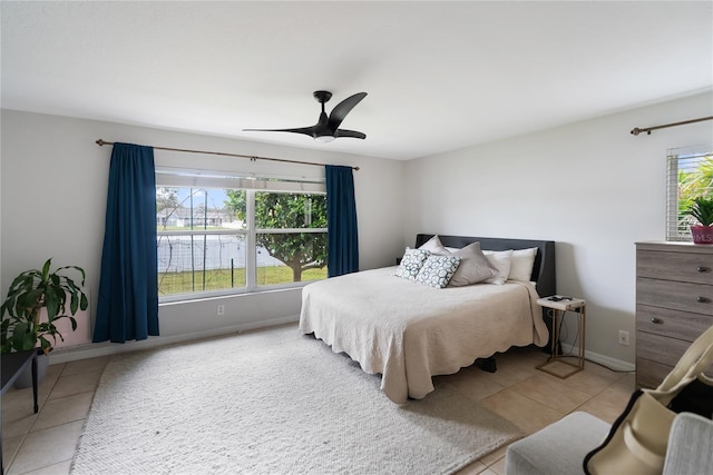 bedroom with tile patterned floors, a ceiling fan, and baseboards