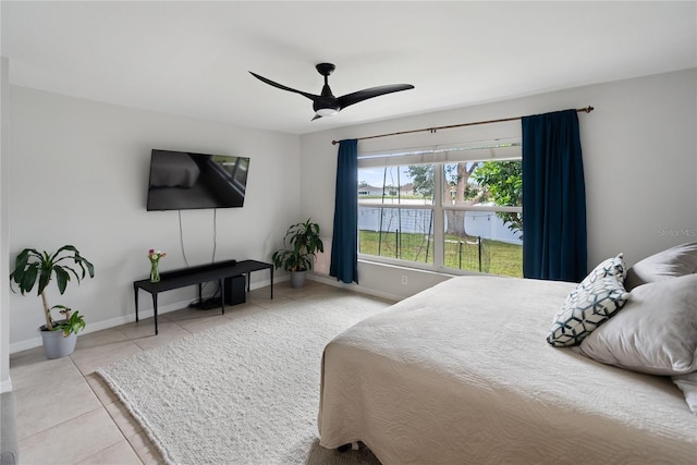 bedroom with ceiling fan, tile patterned flooring, and baseboards