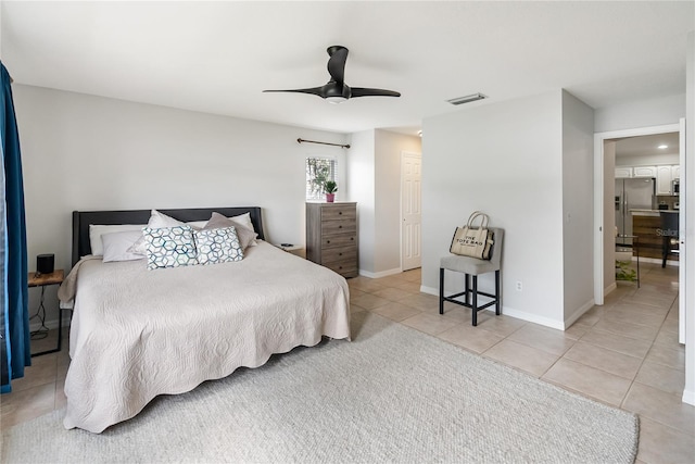 bedroom featuring light tile patterned floors, ceiling fan, visible vents, baseboards, and stainless steel fridge with ice dispenser