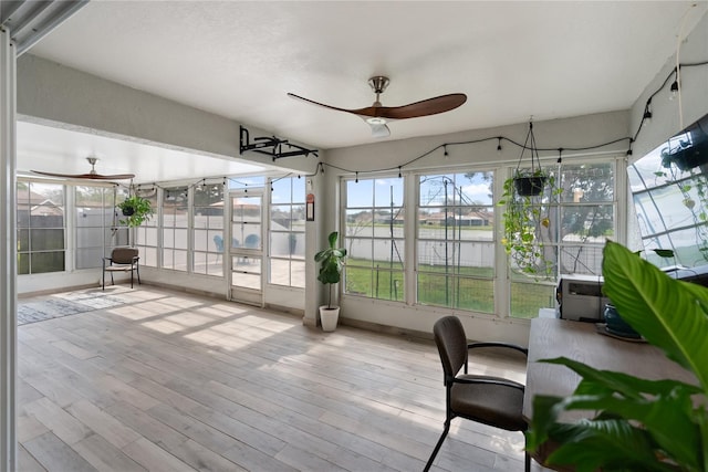 unfurnished sunroom with a ceiling fan