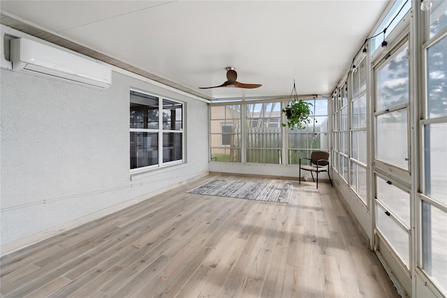 unfurnished sunroom featuring a ceiling fan and a wall mounted AC