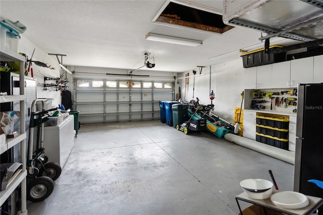 garage featuring a garage door opener and freestanding refrigerator