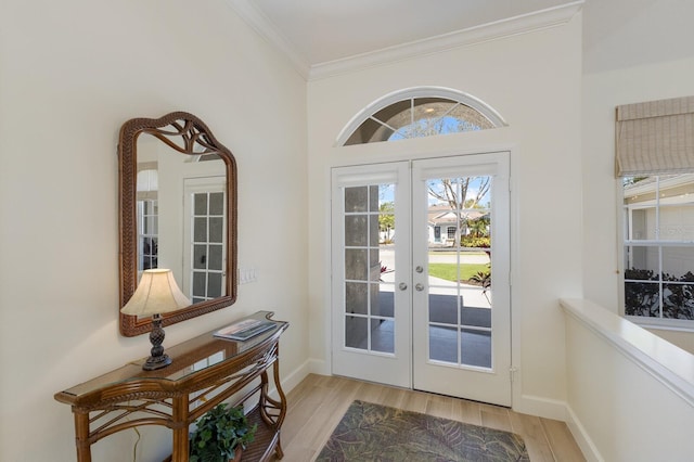 entryway featuring ornamental molding, french doors, baseboards, and light wood finished floors