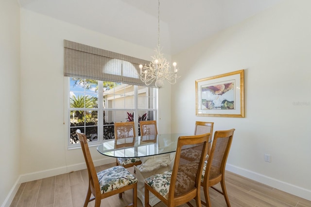 dining room featuring a notable chandelier, baseboards, and light wood-style floors