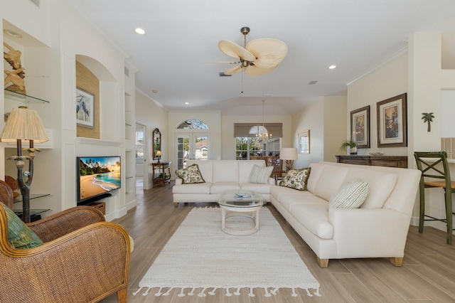 living room with a chandelier, recessed lighting, a fireplace, light wood-style floors, and ornamental molding