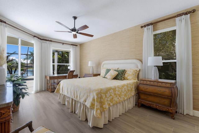 bedroom with access to exterior, ceiling fan, and light wood finished floors