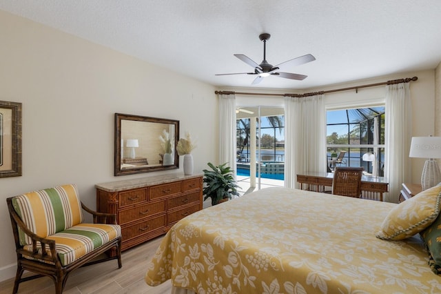 bedroom featuring access to outside, light wood finished floors, and a ceiling fan