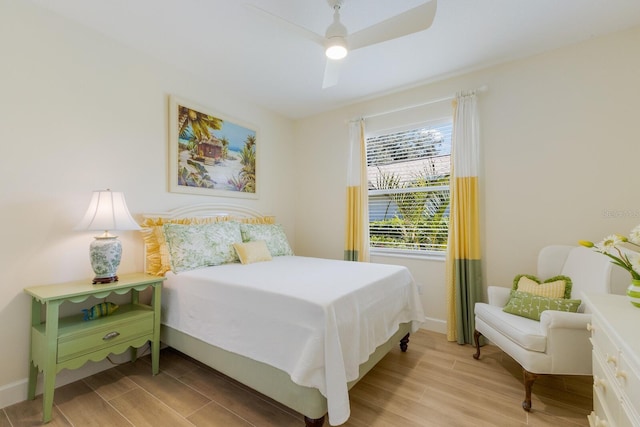 bedroom featuring wood finish floors, a ceiling fan, and baseboards