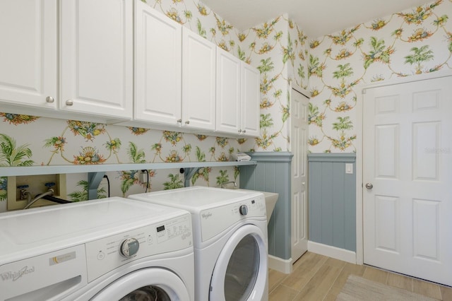 laundry room with a wainscoted wall, light wood finished floors, cabinet space, independent washer and dryer, and wallpapered walls