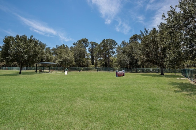 view of community featuring a yard and fence