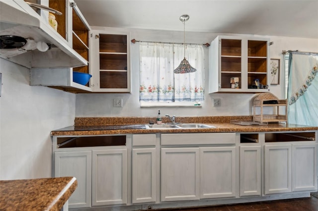 kitchen featuring hanging light fixtures, white cabinetry, open shelves, and a sink