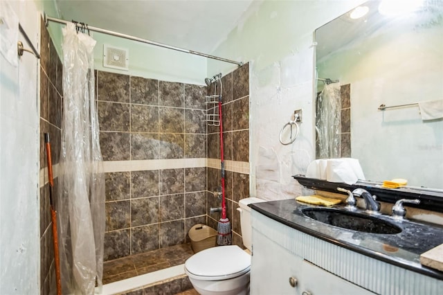 bathroom with toilet, a shower stall, and vanity