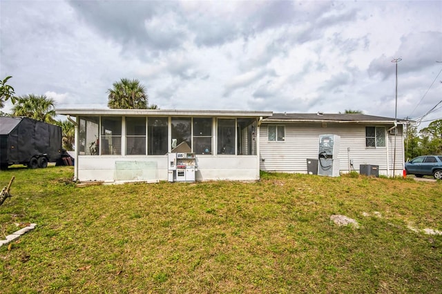 back of property with a sunroom, cooling unit, and a yard