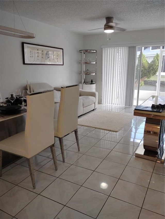 dining area with a ceiling fan, a textured ceiling, and light tile patterned floors