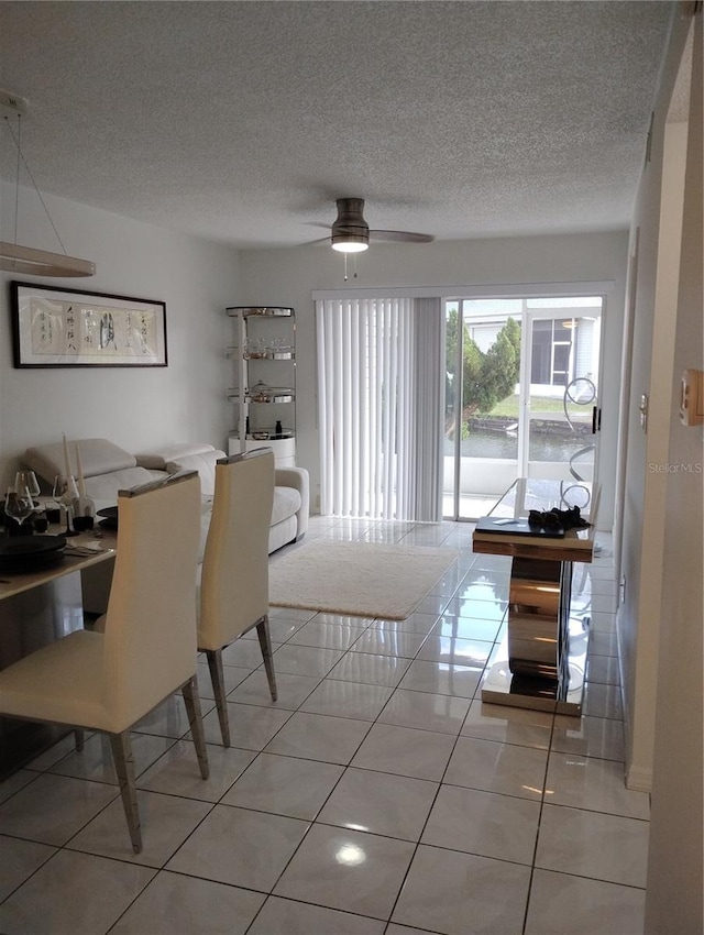 dining room featuring light tile patterned floors, ceiling fan, and a textured ceiling