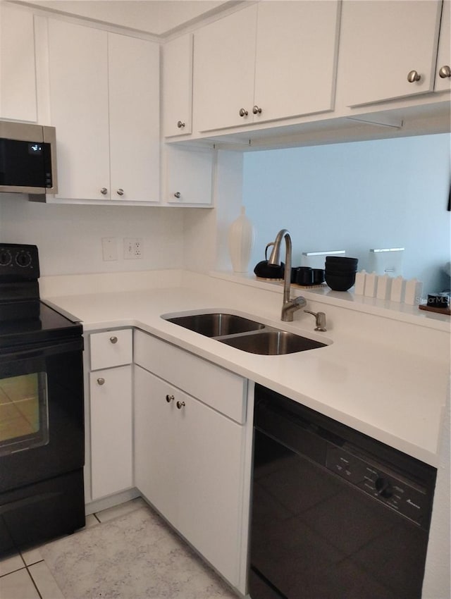 kitchen featuring black appliances, white cabinetry, light countertops, and a sink