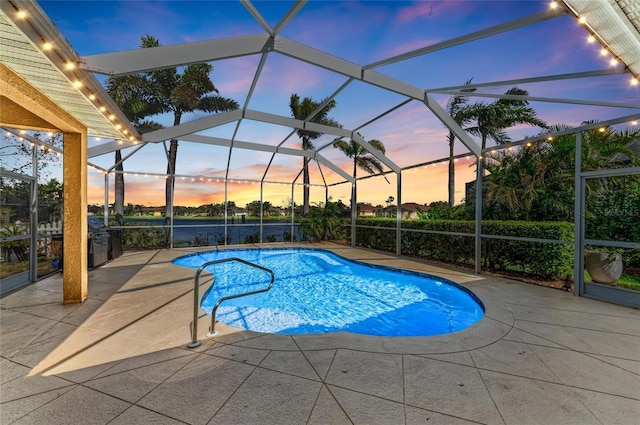 pool at dusk with a lanai, a patio area, and an outdoor pool