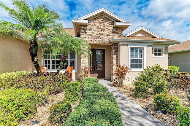 view of front of home featuring stone siding and stucco siding