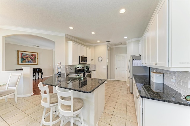 kitchen featuring white cabinets, stainless steel appliances, a sink, and light tile patterned flooring