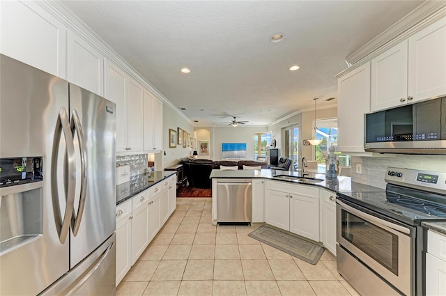 kitchen with light tile patterned floors, tasteful backsplash, appliances with stainless steel finishes, open floor plan, and a sink