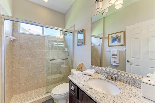 full bath featuring vanity, a shower stall, and toilet