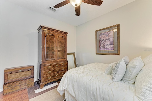 bedroom featuring light wood-style flooring, visible vents, and a ceiling fan