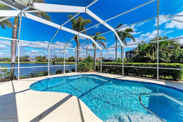 outdoor pool with a lanai, a patio area, and a water view