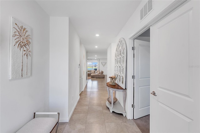 hallway with recessed lighting, visible vents, baseboards, and light tile patterned flooring