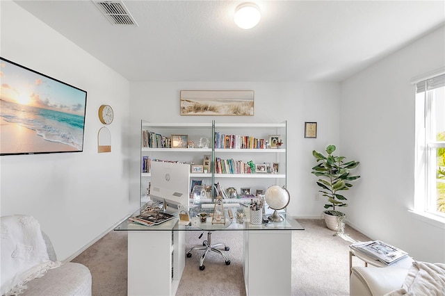 home office featuring baseboards, carpet floors, visible vents, and a healthy amount of sunlight