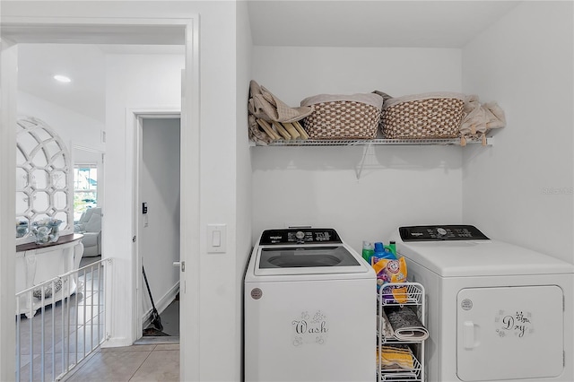 clothes washing area featuring laundry area, light tile patterned floors, and separate washer and dryer