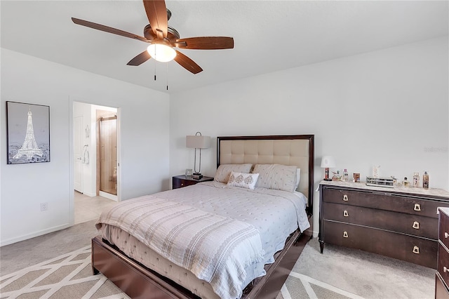 bedroom featuring baseboards, connected bathroom, a ceiling fan, and light colored carpet